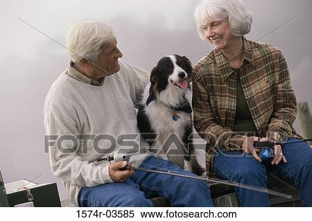 Senior couple sitting on a dock with their dog fishing View Large Photo Image Stock Photography - Senior couple sitting on a dock with their dog fishing. Fotosearch