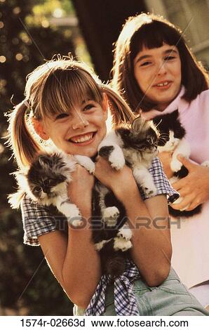 Stock Image - Two girls holding kittens. Fotosearch