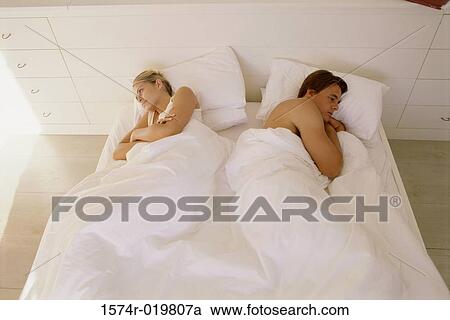 High angle view of a young couple lying on the bed View Large Photo Image Stock Image - High angle view of a young couple lying on the bed. Fotosearch
