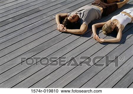 High angle view of a young couple lying on wooden planks View Large Photo Image Stock Image - High angle view of a young couple lying on wooden planks. Fotosearch