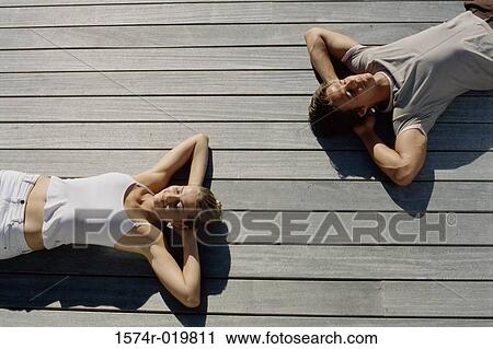 High angle view of a young couple lying on wooden planks View Large Photo Image Stock Image - High angle view of a young couple lying on wooden planks. Fotosearch