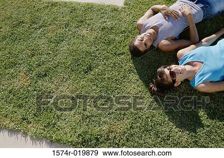High angle view of a young couple lying on the grass View Large Photo Image Stock Photo - High angle view of a young couple lying on the grass. Fotosearch