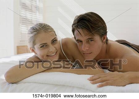 Portrait of a young couple lying on the bed View Large Photo Image Picture - Portrait of a young couple lying on the bed. Fotosearch