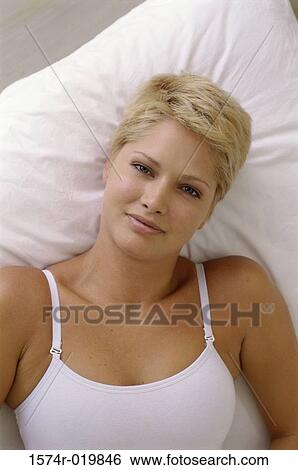 Portrait of a young woman lying on the bed View Large Photo Image Stock Photograph - Portrait of a young woman lying on the bed. Fotosearch