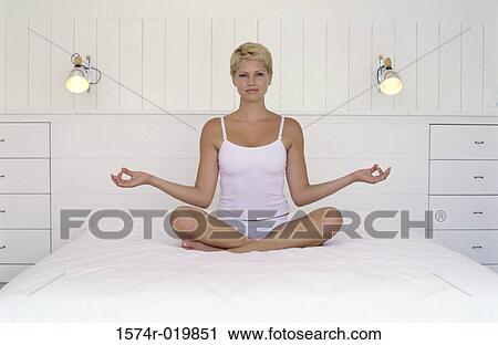 Portrait of a young woman sitting in a lotus position View Large Photo Image Stock Image - Portrait of a young woman sitting in a lotus position. Fotosearch
