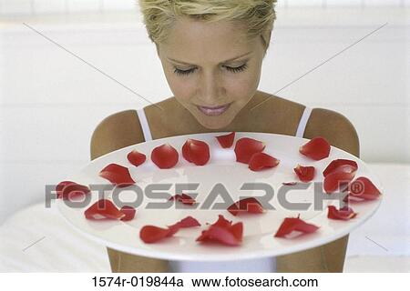 Young woman holding a plate with rose petals View Large Photo Image Stock Image - Young woman holding a plate with rose petals. Fotosearch