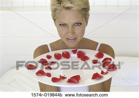Young woman holding a plate with rose petals View Large Photo Image Stock Image - Young woman holding a plate with rose petals. Fotosearch