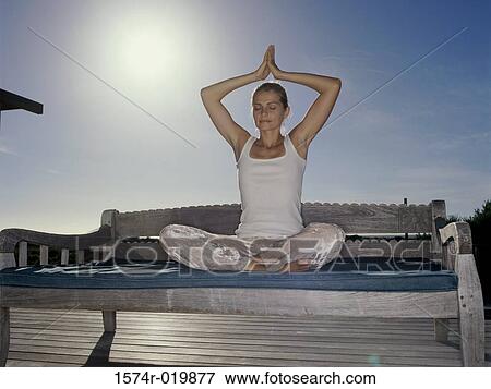 Young woman practicing yoga on a bench View Large Photo Image Stock Photo - Young woman practicing yoga on a bench. Fotosearch