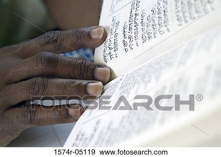 Close-up a person holding the Koran View Large Photo Image Stock Photo - Close-up a person holding the Koran. Fotosearch