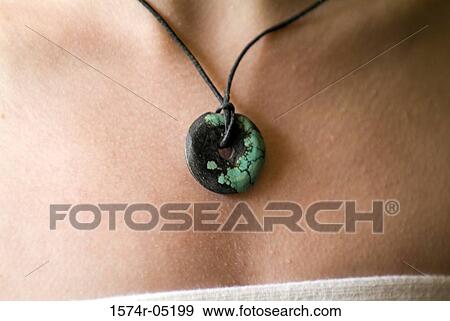 Stock Photo - Close-up of a Buddhist prayer medallion around a person's neck. Fotosearch