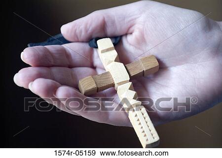 Stock Photo - Close-up of a person holding a wooden cross, New Mexico, USA. Fotosearch