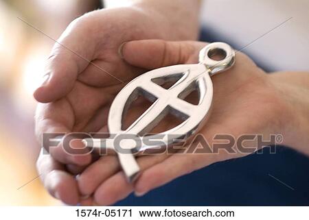 Close-up of a person holding an ichthus fish symbol View Large Photo Image Stock Image - Close-up of a person holding an ichthus fish symbol. Fotosearch