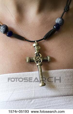 Stock Image - Close-up of a person wearing a cross around the neck. Fotosearch