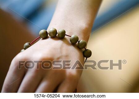 Close-up of a person's hand wearing a Buddhist bracelet View Large Photo Image Picture - Close-up of a person's hand wearing a Buddhist bracelet. Fotosearch