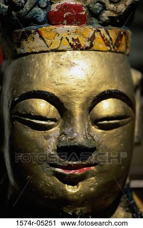 Stock Image - Close-up of the face of a Buddha statue. Fotosearch