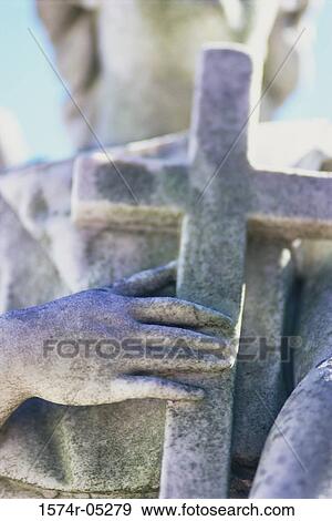 Close-up of the hands of a statue holding a cross View Large Photo Image Stock Photo - Close-up of the hands of a statue holding a cross. Fotosearch