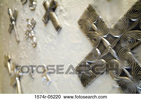 Stock Image - Low angle view of crosses mounted on a wall. Fotosearch