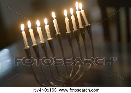 Stock Image - Menorah illuminated during Hanukkah festival. Fotosearch