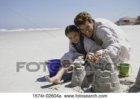 Father and his daughter making sand castles on the beach View Large Photo Image Stock Image - Father and his daughter making sand castles on the beach. Fotosearch