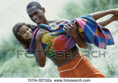 Father carrying his daughter on the beach View Large Photo Image Stock Image - Father carrying his daughter on the beach. Fotosearch