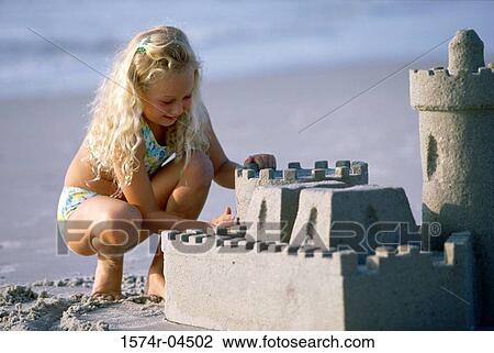 Girl building a sand castle on the beach View Large Photo Image Stock Image - Girl building a sand castle on the beach. Fotosearch
