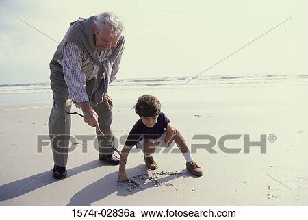 Grandfather playing with his grandson on the beach View Large Photo Image Stock Image - Grandfather playing with his grandson on the beach. Fotosearch
