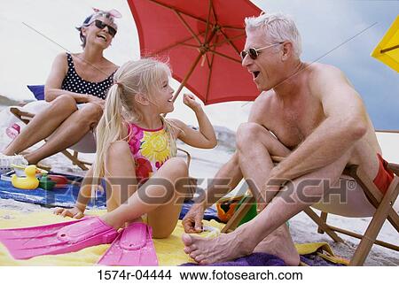 Picture - Grandparents with their granddaughter on the beach. Fotosearch