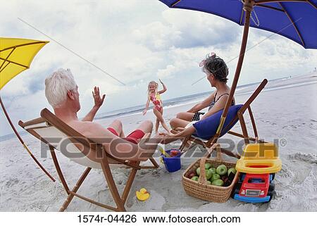 Stock Photograph - Grandparents with their granddaughter on the beach. Fotosearch