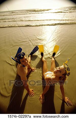 High angle view of a teenage couple sitting on the beach wearing snorkels and flippers View Large Photo Image Stock Image - High angle view of a teenage couple sitting on the beach wearing snorkels and flippers. Fotosearch