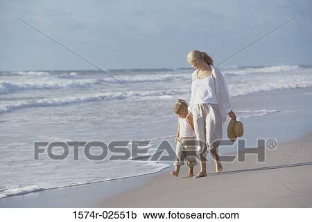 Mother walking with her daughter on the beach View Large Photo Image Stock Image - Mother walking with her daughter on the beach. Fotosearch