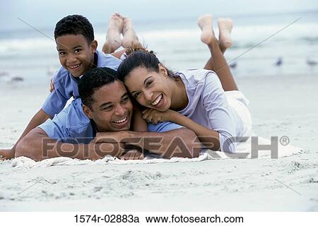 Parents lying with their son on the beach View Large Photo Image Stock Image - Parents lying with their son on the beach. Fotosearch