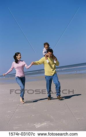 Parents playing with their daughter on the beach View Large Photo Image Stock Image - Parents playing with their daughter on the beach. Fotosearch