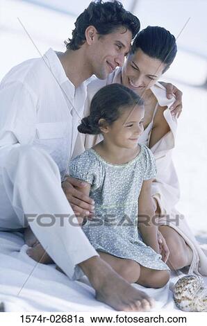 Parents sitting with their daughter on the beach View Large Photo Image Stock Image - Parents sitting with their daughter on the beach. Fotosearch