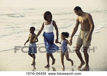 Parents walking with their son and daughter on the beach View Large Photo Image Picture - Parents walking with their son and daughter on the beach. Fotosearch