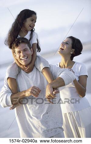 Stock Image - Parents with their daughter on the beach. Fotosearch