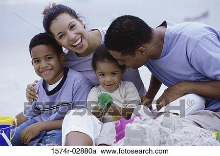 Stock Image - Parents with their son and daughter on the beach. Fotosearch