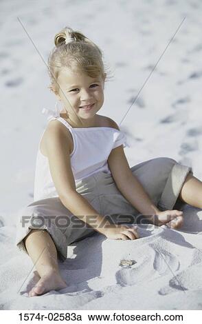 Portrait of a girl playing in the sand on the beach View Large Photo Image Stock Image - Portrait of a girl playing in the sand on the beach. Fotosearch