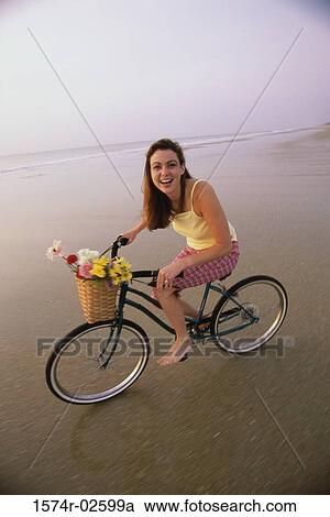Portrait of a young woman cycling on the beach View Large Photo Image Stock Image - Portrait of a young woman cycling on the beach. Fotosearch