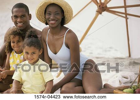 Portrait of parents with their two daughters sitting on the beach View Large Photo Image Stock Image - Portrait of parents with their two daughters sitting on the beach. Fotosearch
