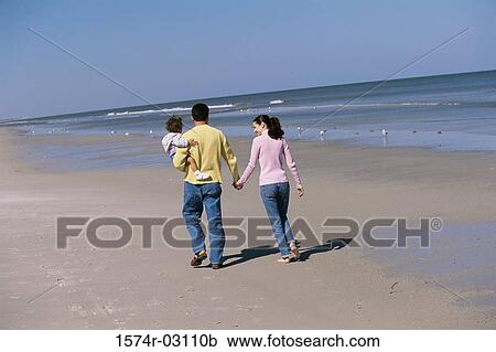 Rear view of parents playing with their daughter on the beach View Large Photo Image Stock Image - Rear view of parents playing with their daughter on the beach. Fotosearch