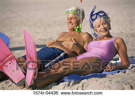 Senior couple lying down on the beach wearing snorkeling gear View Large Photo Image Stock Photograph - Senior couple lying down on the beach wearing snorkeling gear. Fotosearch