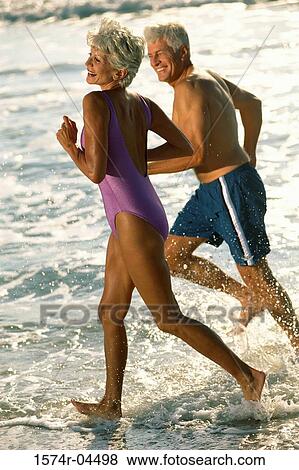 Senior couple running on the beach View Large Photo Image Stock Photo - Senior couple running on the beach. Fotosearch