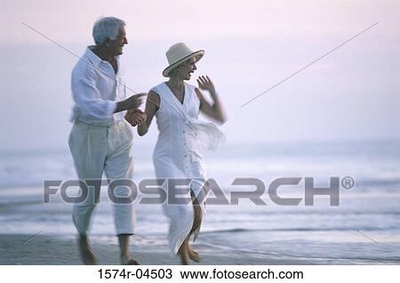 Senior couple walking on the beach View Large Photo Image Stock Image - Senior couple walking on the beach. Fotosearch