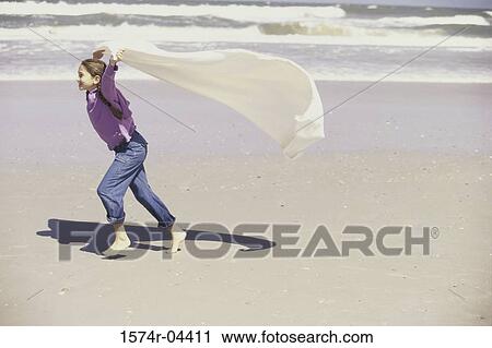 Side profile of a girl holding up a blanket running on the beach View Large Photo Image Stock Image - Side profile of a girl holding up a blanket running on the beach. Fotosearch