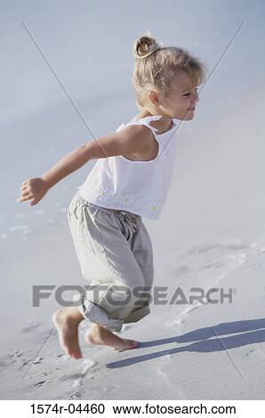 Stock Image - Side profile of a girl running on the beach. Fotosearch