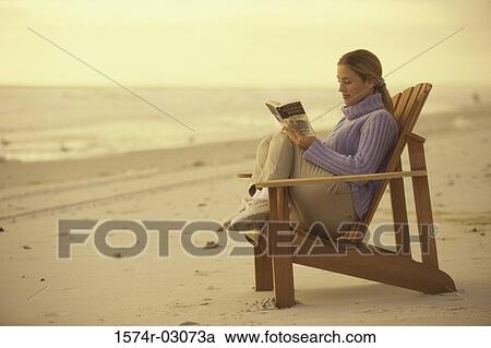 Side profile of a young woman reading a book on the beach View Large Photo Image Stock Image - Side profile of a young woman reading a book on the beach. Fotosearch