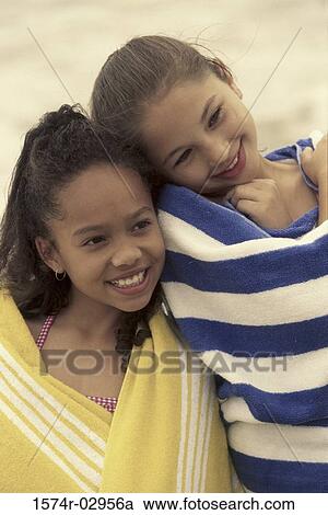 Two girls wrapped in towels on the beach View Large Photo Image Stock Image - Two girls wrapped in towels on the beach. Fotosearch