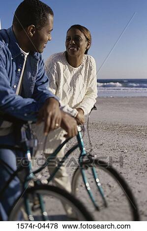 Young couple on bicycles on the beach View Large Photo Image Stock Photo - Young couple on bicycles on the beach. Fotosearch