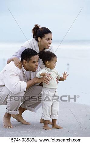 Young couple on the beach with their daughter View Large Photo Image Stock Image - Young couple on the beach with their daughter. Fotosearch