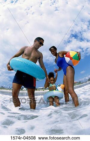 Young couple on the beach with their daughter View Large Photo Image Stock Photo - Young couple on the beach with their daughter. Fotosearch